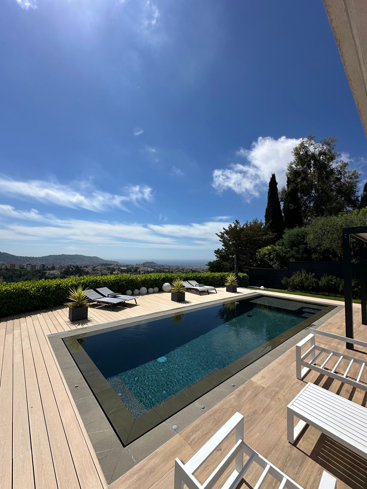 Piscine miroir sur une terrasse dominant la ville et la mer