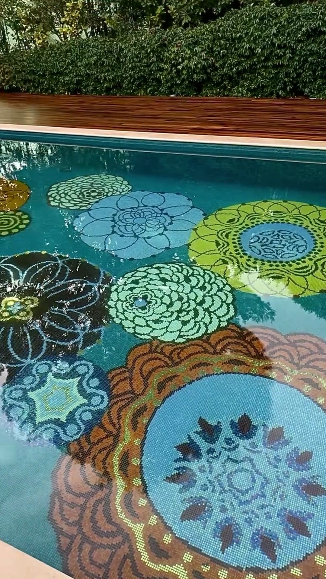 Fond de piscine en mosaïque à motifs floraux sous une eau limpide
