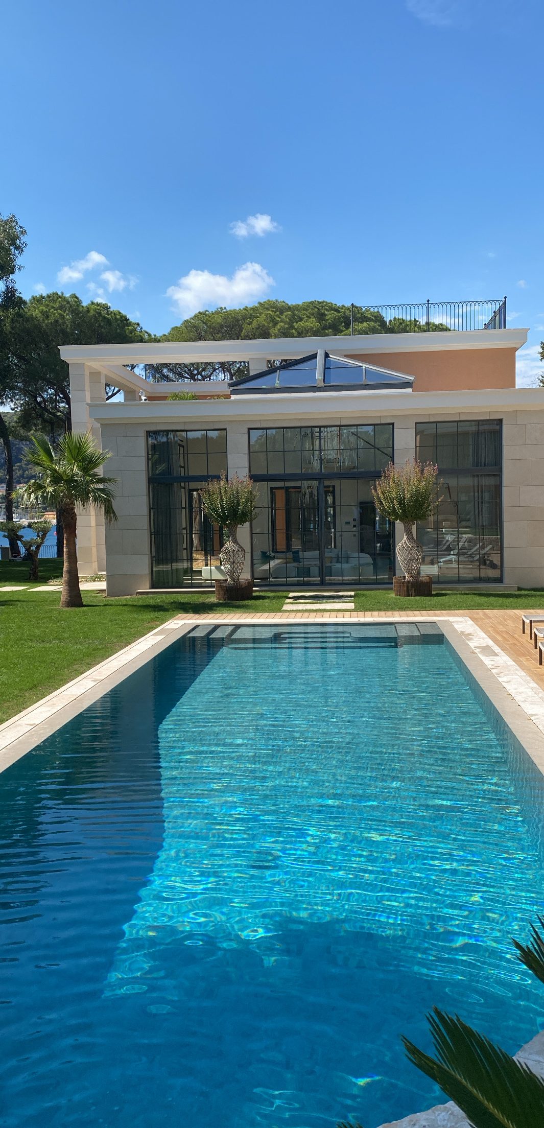 Piscine devant une villa à grande verrière