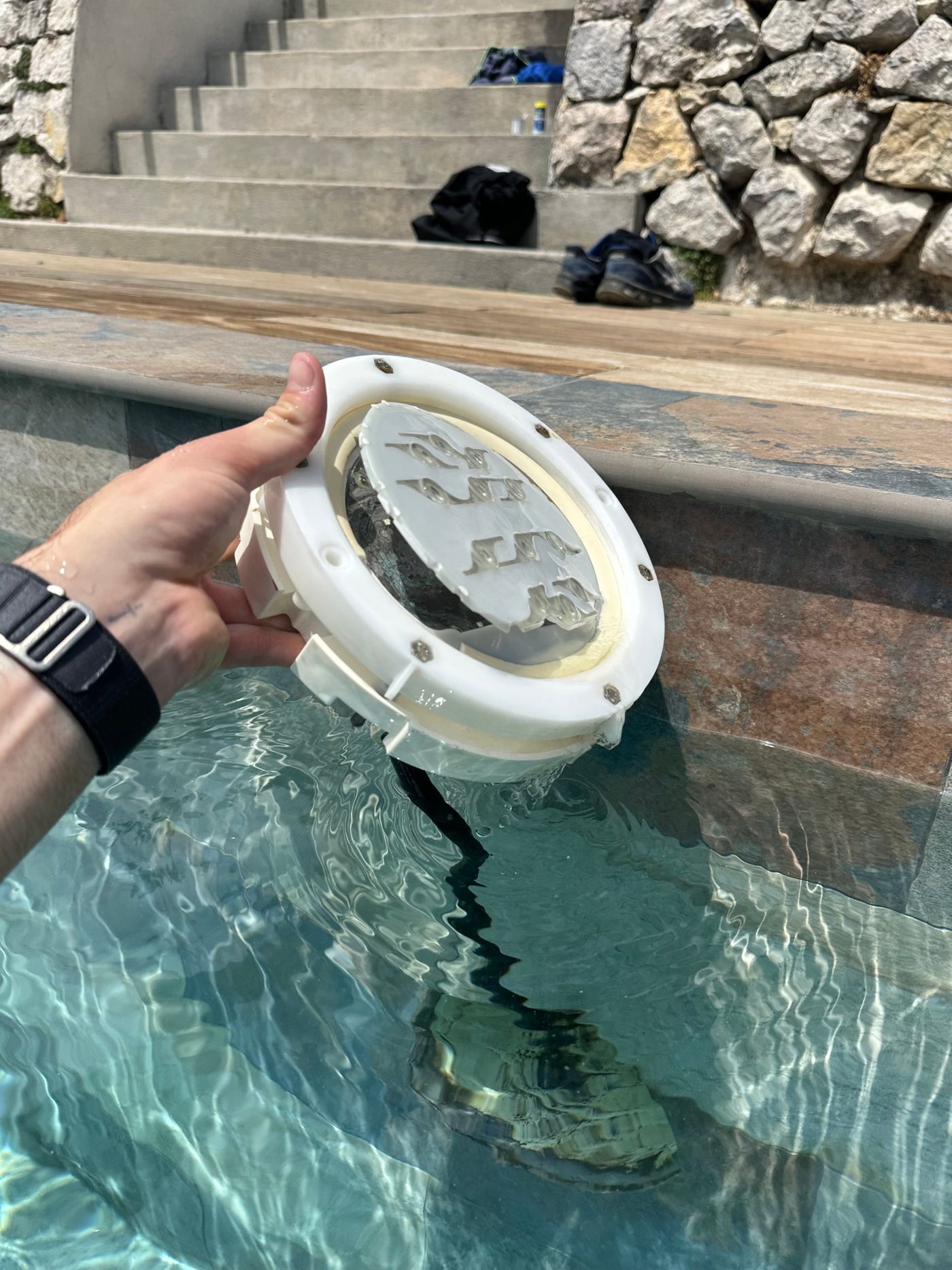 Projecteur de piscine sorti de l'eau au bord d'un second bassin